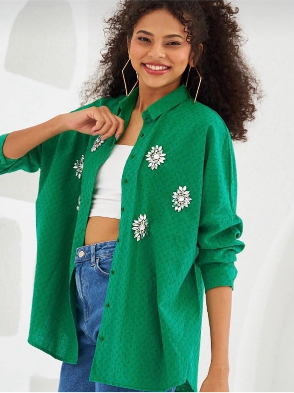 emerald green button-down shirt with large rhinestone flower/star brooches.